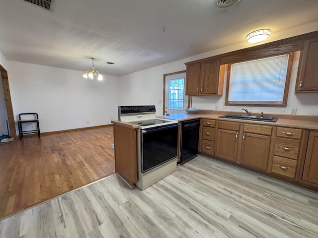 kitchen featuring sink, hanging light fixtures, electric range, black dishwasher, and light wood-type flooring