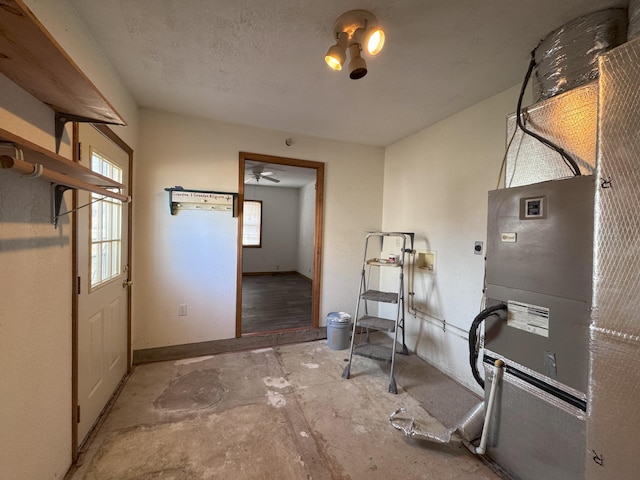 interior space featuring plenty of natural light, heating unit, and a textured ceiling