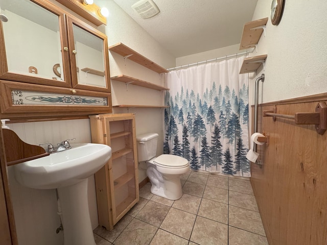 bathroom with sink, tile patterned flooring, a textured ceiling, curtained shower, and toilet