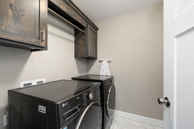 laundry room featuring cabinets and washer and dryer