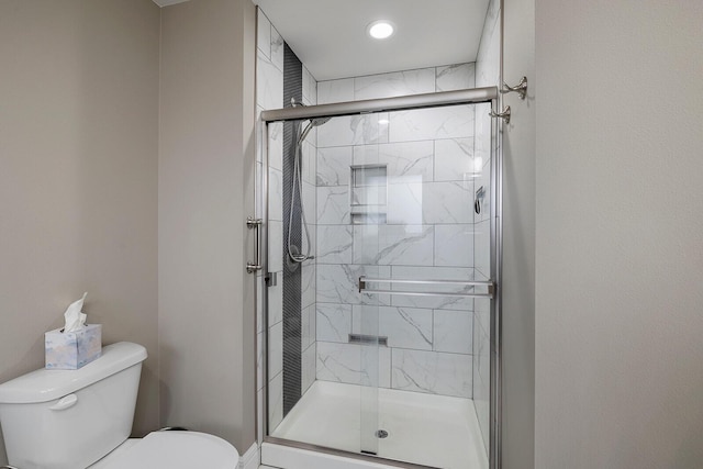 bathroom with an enclosed shower and toilet