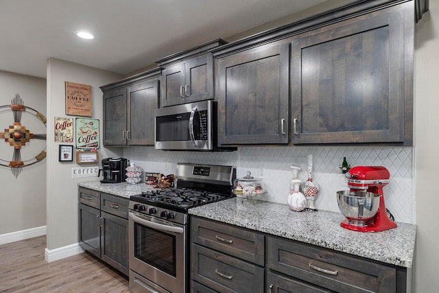 kitchen with backsplash, dark brown cabinets, and stainless steel appliances