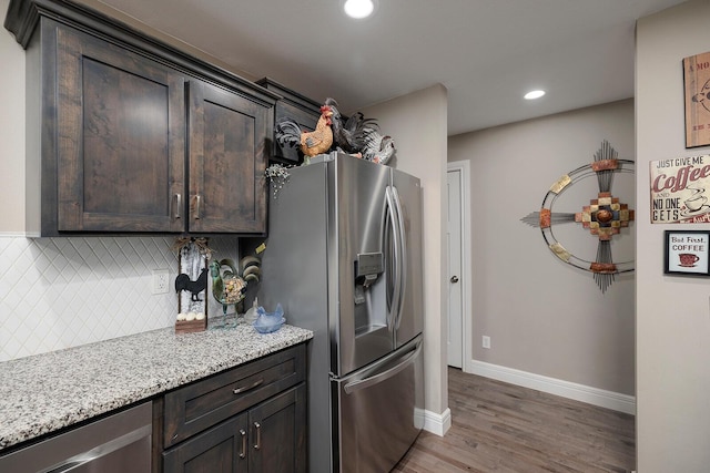 kitchen with light stone counters, dark brown cabinets, and appliances with stainless steel finishes