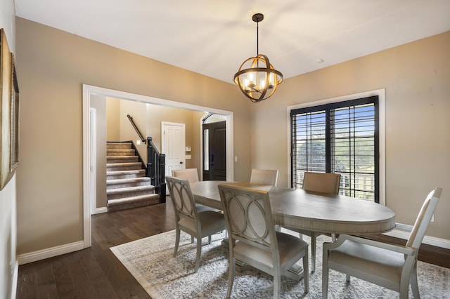 dining room with dark hardwood / wood-style flooring and a chandelier