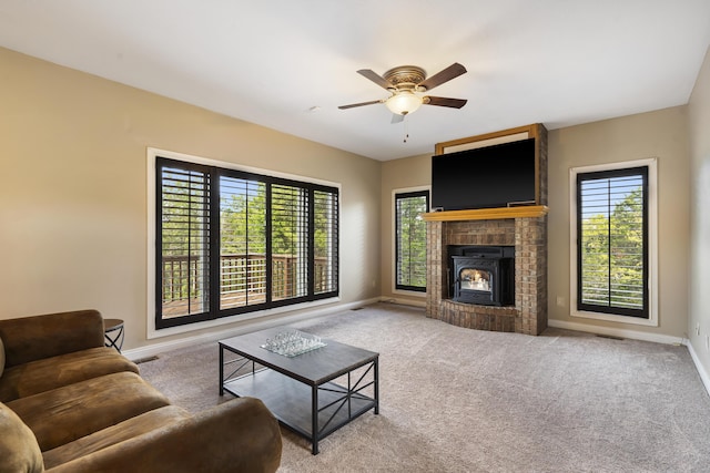 carpeted living room with plenty of natural light, a fireplace, and ceiling fan