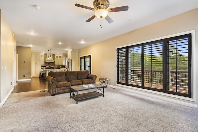 living room with ceiling fan and carpet