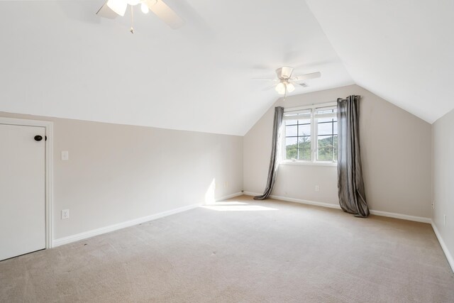 additional living space featuring vaulted ceiling, light colored carpet, and ceiling fan