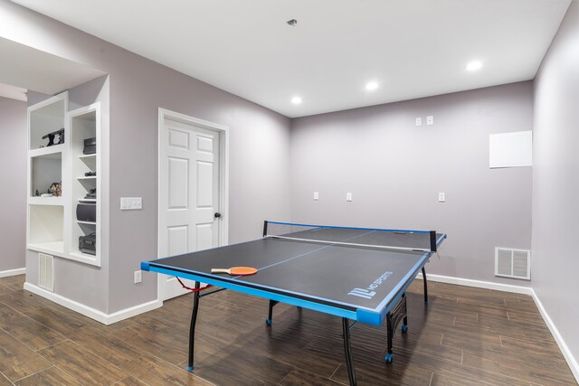 recreation room featuring dark hardwood / wood-style floors and built in shelves