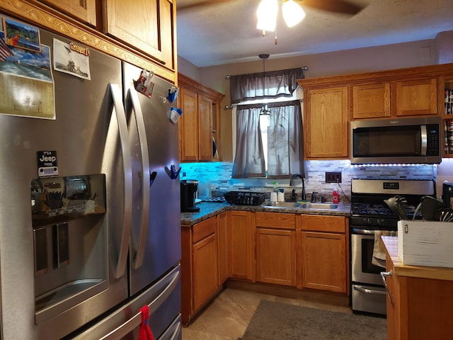 kitchen with appliances with stainless steel finishes, tasteful backsplash, sink, hanging light fixtures, and ceiling fan