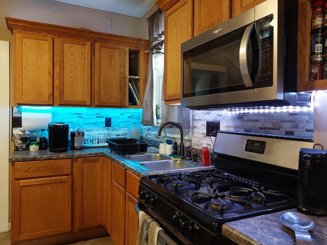 kitchen with appliances with stainless steel finishes, sink, and backsplash