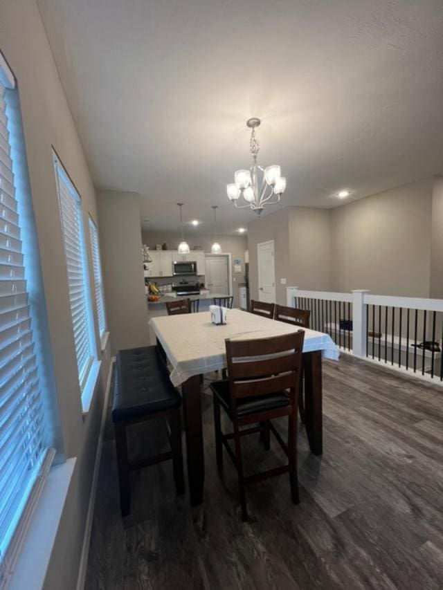 dining room featuring dark wood-type flooring and an inviting chandelier