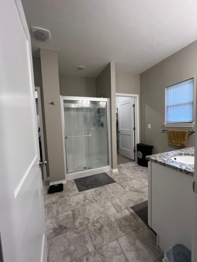 bathroom featuring vanity and a shower with shower door