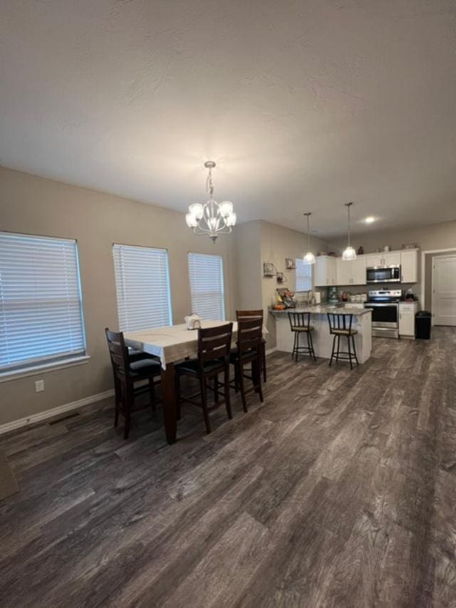 dining area with a notable chandelier and dark hardwood / wood-style flooring