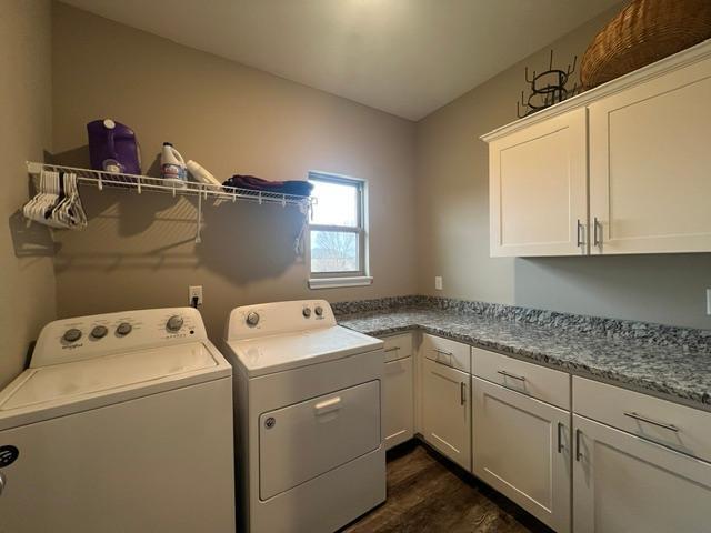 laundry area with cabinets, dark hardwood / wood-style flooring, and washer and dryer