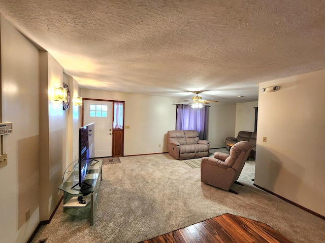 living room featuring ceiling fan, carpet, and a textured ceiling