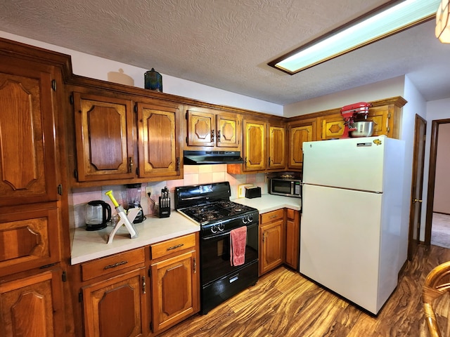 kitchen with light hardwood / wood-style flooring, black gas range, a textured ceiling, decorative backsplash, and white fridge