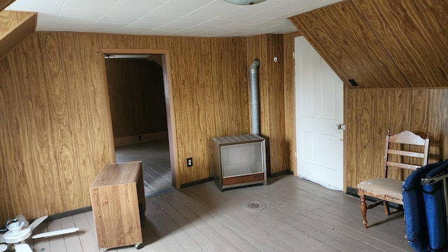 sitting room with light wood-type flooring and wood walls