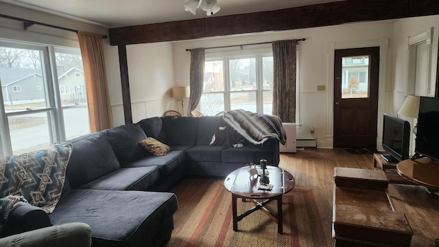 living room featuring hardwood / wood-style flooring, a baseboard radiator, and beam ceiling