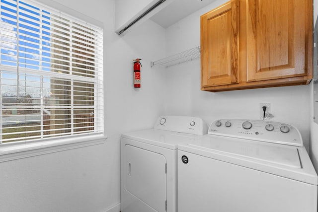 laundry area with a healthy amount of sunlight, cabinets, and washing machine and clothes dryer