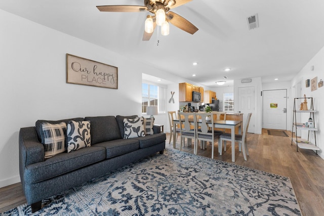 living room with wood-type flooring and ceiling fan