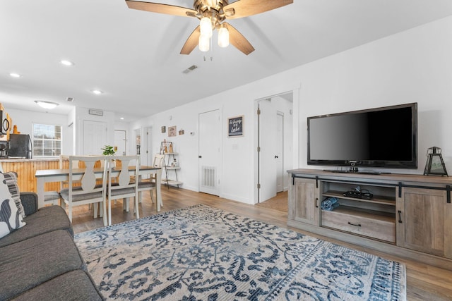 living room with ceiling fan and light hardwood / wood-style floors