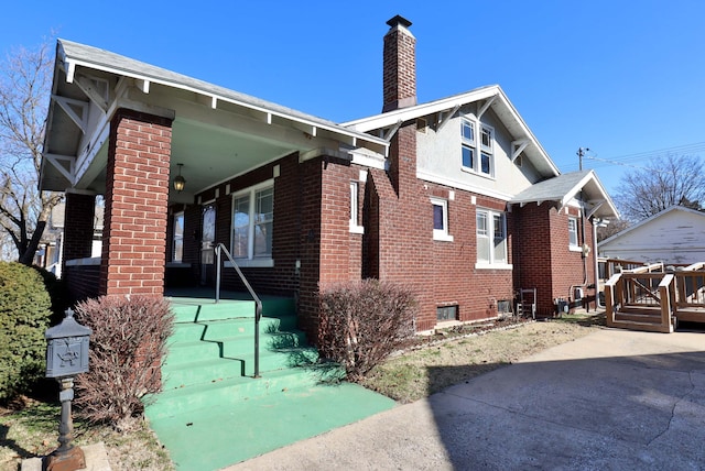 view of side of home featuring brick siding and a chimney