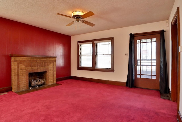 unfurnished living room with carpet floors, a brick fireplace, a textured ceiling, and a ceiling fan