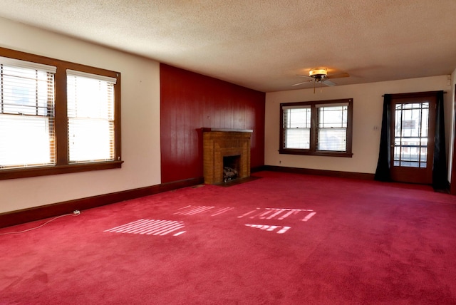 unfurnished living room featuring a textured ceiling, carpet floors, a fireplace with flush hearth, and baseboards