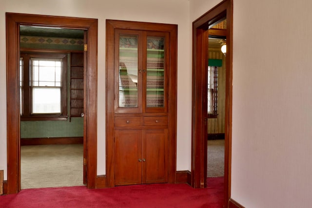 corridor featuring carpet and baseboards