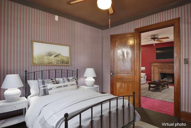 bedroom featuring wallpapered walls, carpet, a fireplace, and ceiling fan