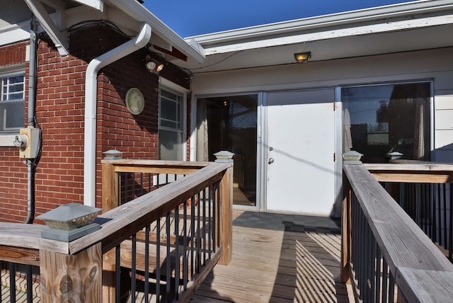 property entrance featuring brick siding and a deck