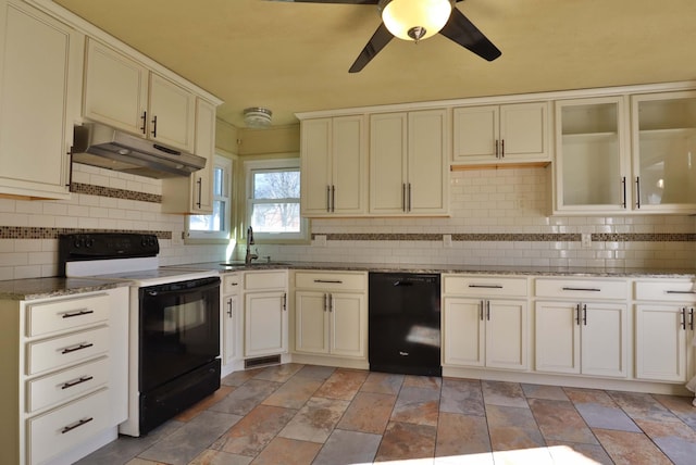 kitchen featuring tasteful backsplash, a sink, under cabinet range hood, and black appliances