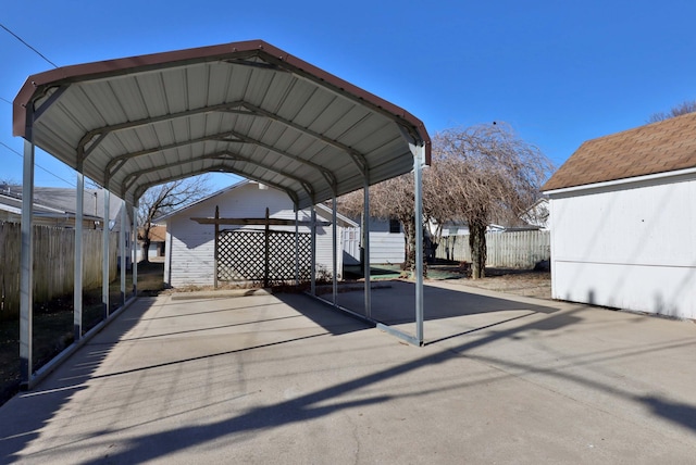 view of car parking with fence and a carport