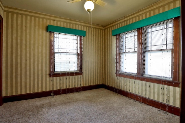 carpeted empty room featuring baseboards, a healthy amount of sunlight, and wallpapered walls