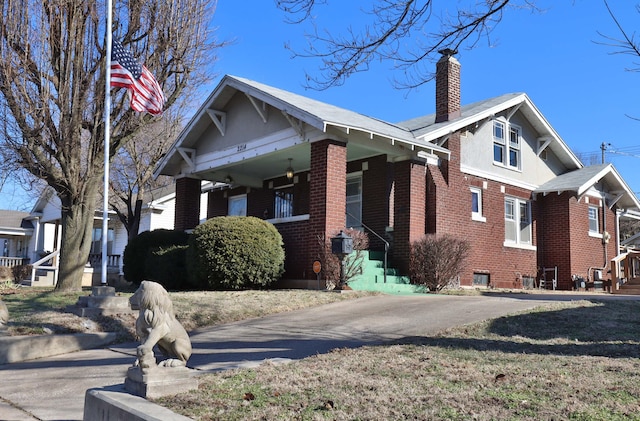 view of front of property featuring brick siding and a chimney