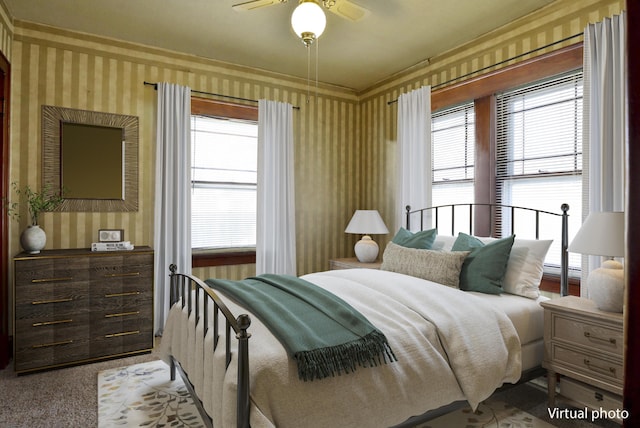 bedroom with ceiling fan, multiple windows, and wallpapered walls