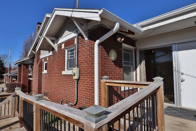 property entrance featuring brick siding and a wooden deck