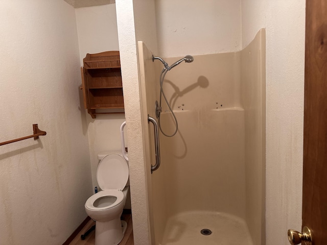 bathroom featuring toilet and a shower