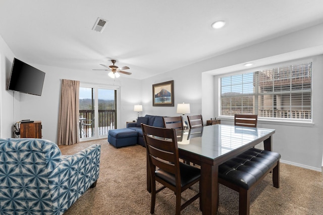 dining area featuring ceiling fan and carpet