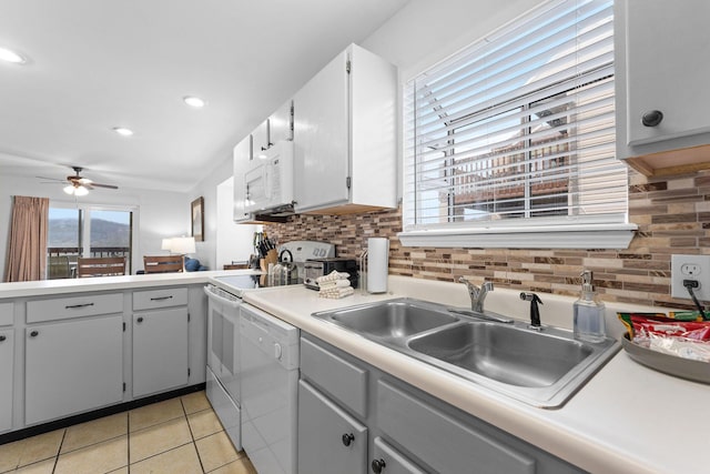 kitchen featuring tasteful backsplash, sink, white appliances, and light tile patterned floors