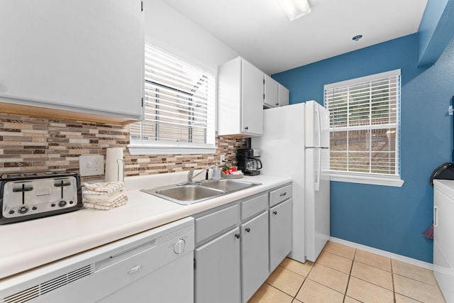 kitchen with light tile patterned floors, sink, white appliances, white cabinets, and decorative backsplash