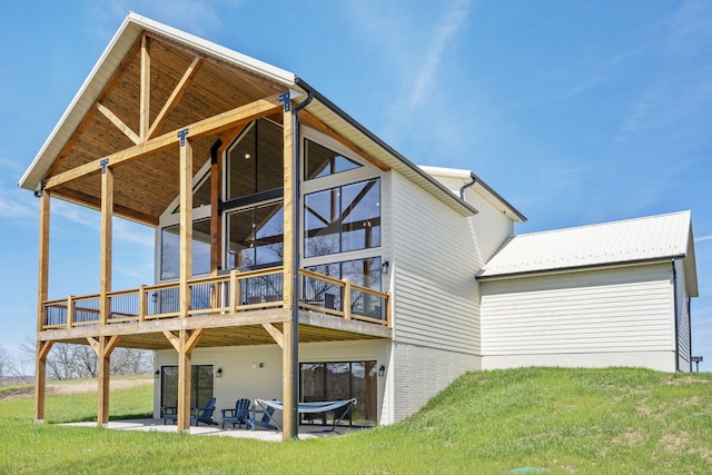 rear view of property featuring a patio area and a lawn