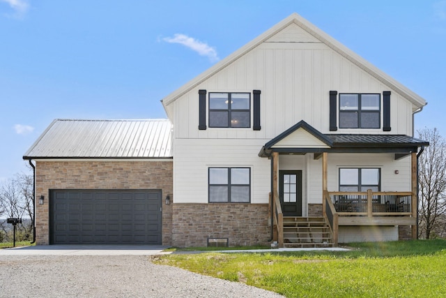 view of front of property with a garage, a front lawn, and covered porch