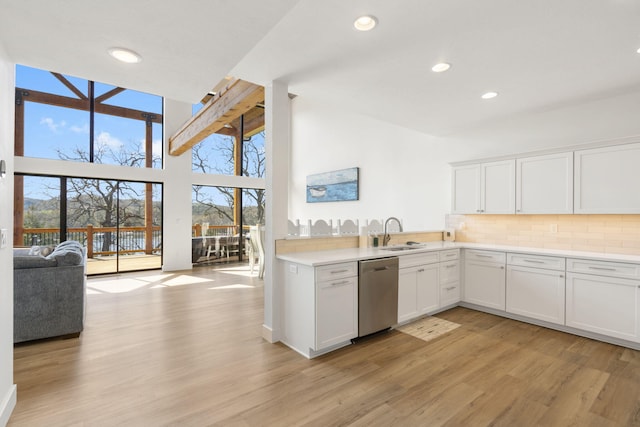 kitchen featuring sink, dishwasher, light hardwood / wood-style floors, decorative backsplash, and white cabinets