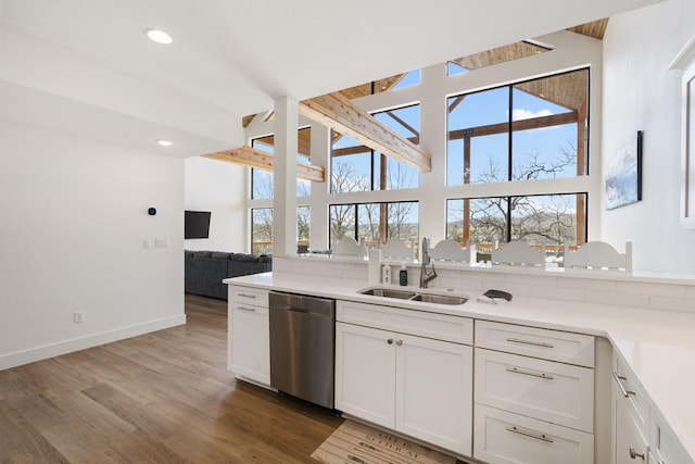 kitchen with a wealth of natural light, dishwasher, sink, and white cabinets