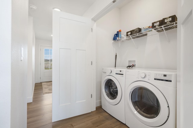 washroom featuring washing machine and clothes dryer and dark hardwood / wood-style floors