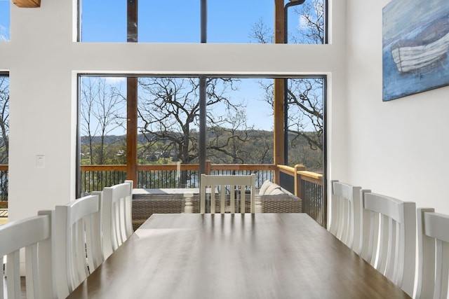 dining space featuring a high ceiling and a water view