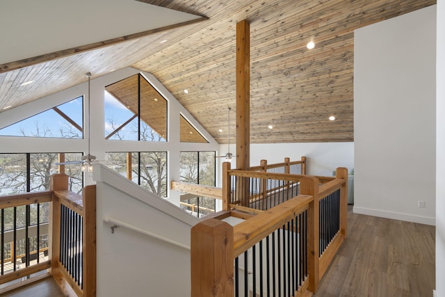 hall with dark wood-type flooring, a healthy amount of sunlight, high vaulted ceiling, and wooden ceiling