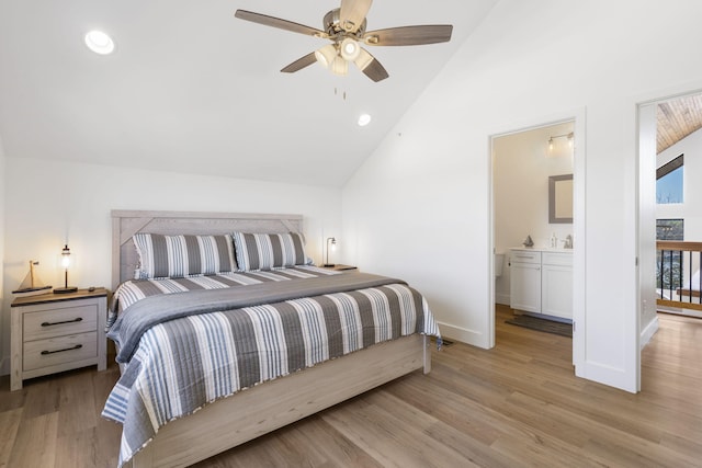 bedroom featuring ceiling fan, ensuite bathroom, vaulted ceiling, and light hardwood / wood-style flooring