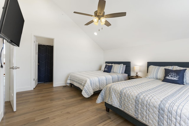 bedroom with ceiling fan, dark hardwood / wood-style floors, and vaulted ceiling